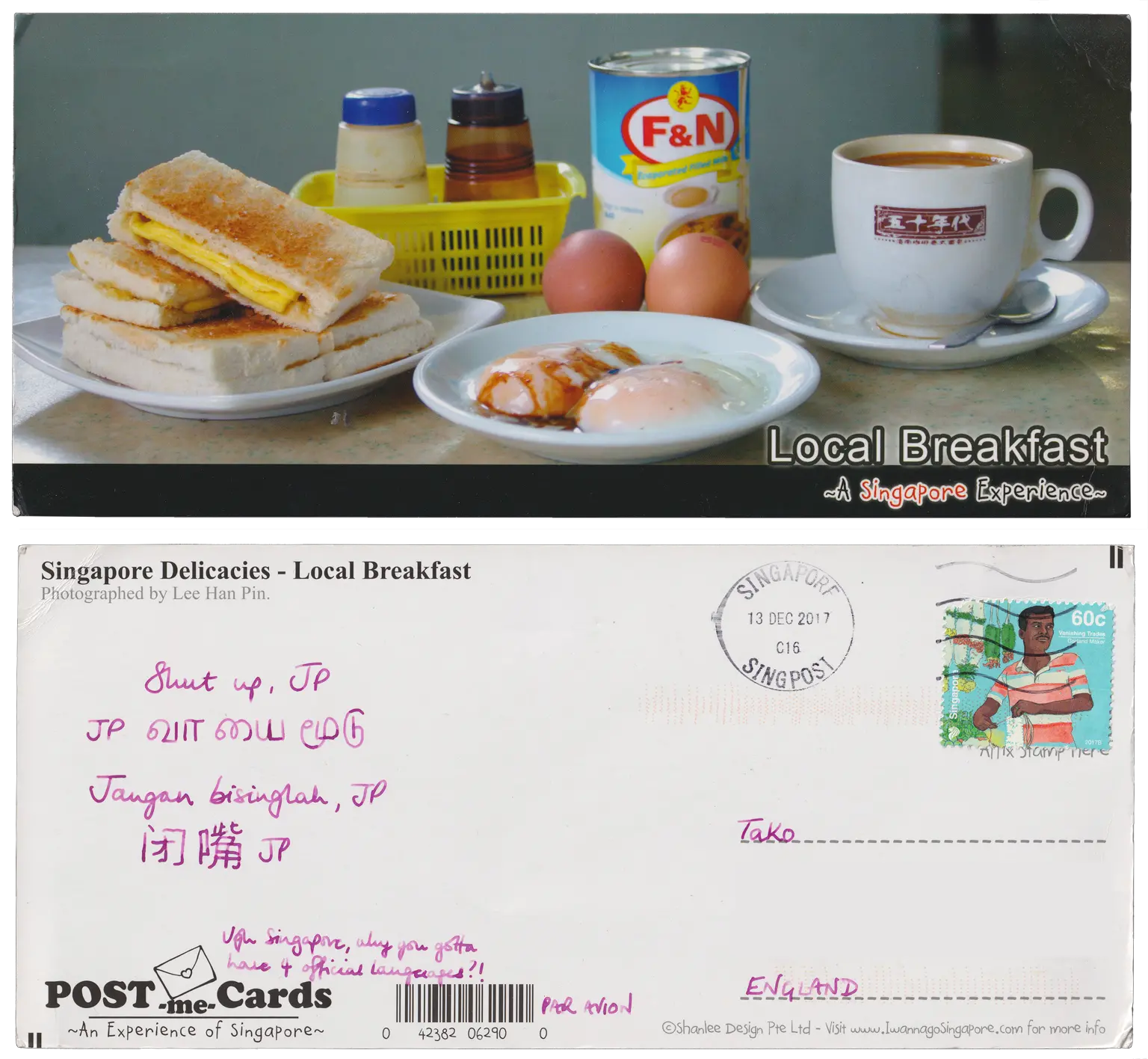 Both sides of a postcard. On the front: A photograph of a "local breakfast", including a plate of toast sandwiches with a yellow (egg or cheese) filling, two hardboiled eggs, a cup of coffee. On the back: Shut up, JP
JP வாயை மூடு
Jangan bisinglah, JP
闭嘴JP

Ugh Singapore, why you gotta have 4 official languages?!
