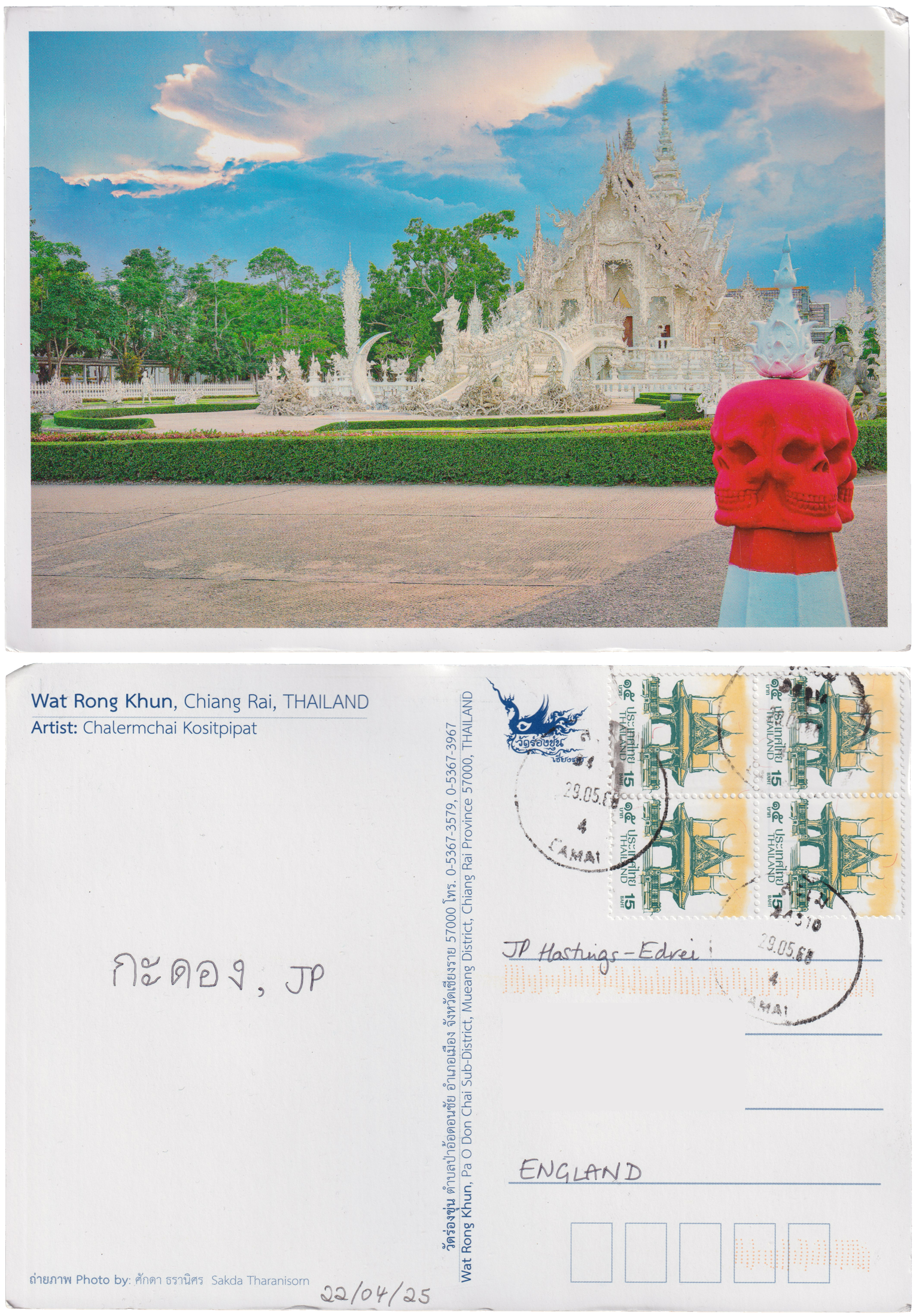 Both sides of a postcard. On the front: The intricate, white stone Wat Rong Khun, with a low hedge around it and a bollard-like pillar in the foreground with a four-faced red skull atop it. On the back: กะดอง, JP